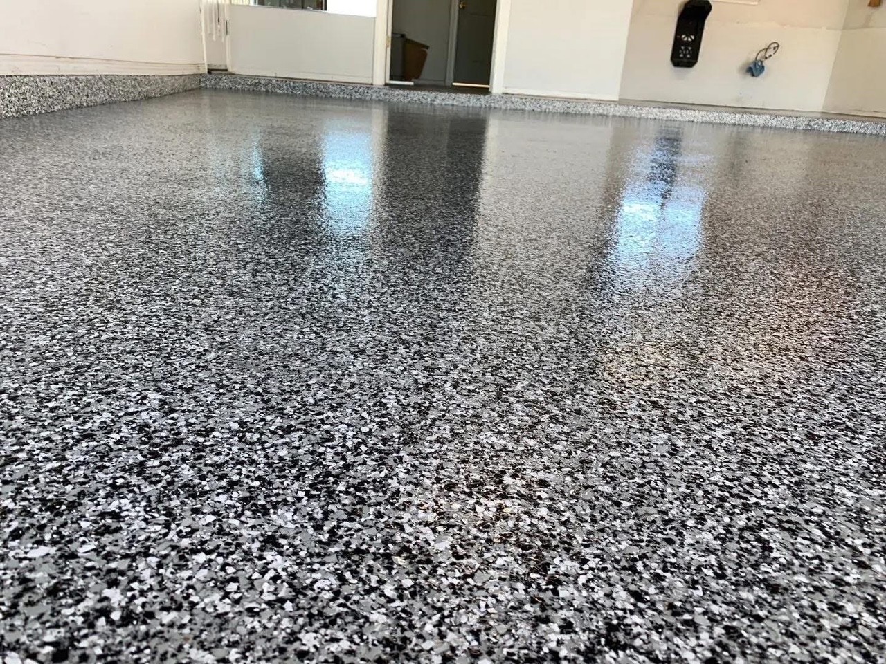 Close-up of a glossy black, white, and gray domino flake epoxy floor